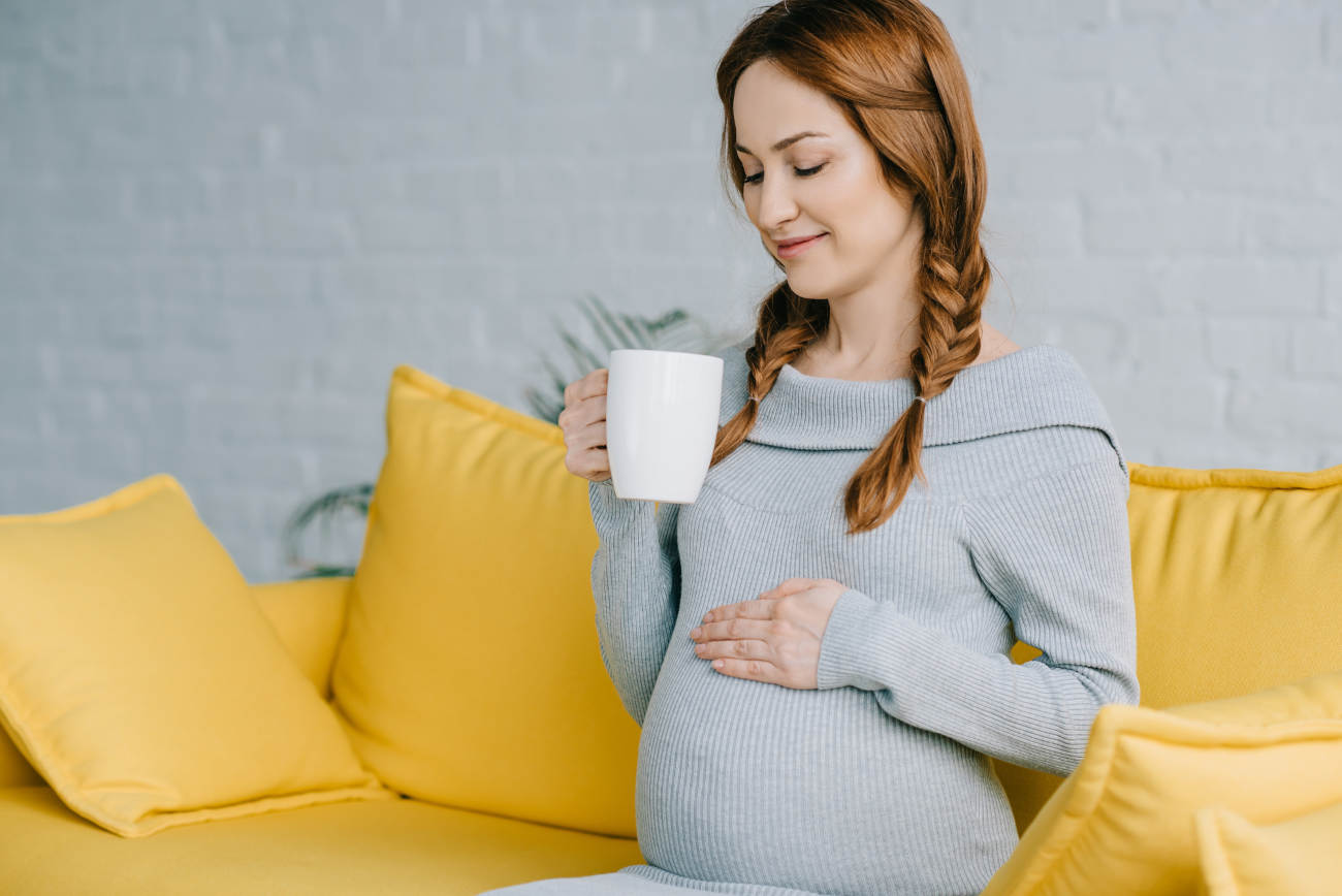 schwangere frau trinkt kaffee