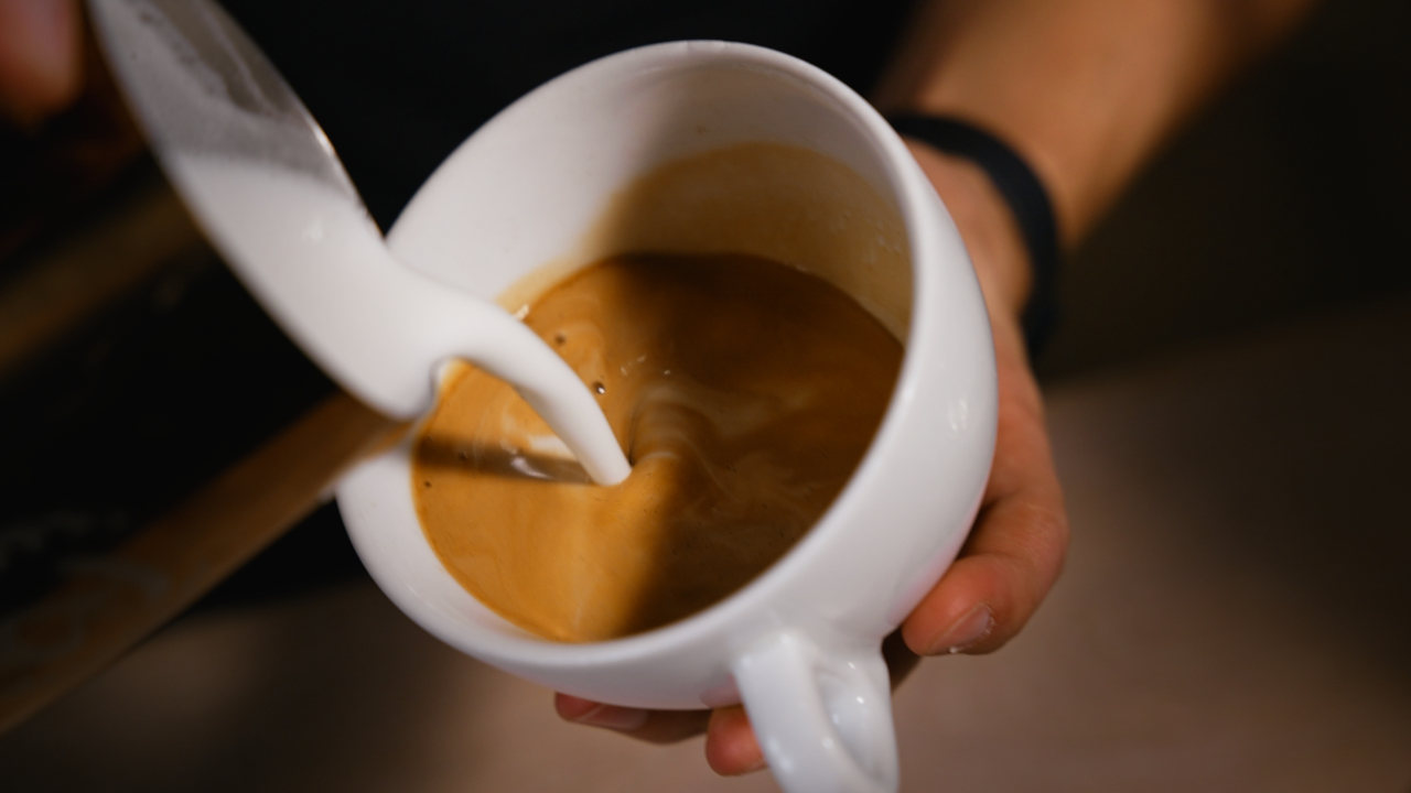 Milchbasis wird in die Tasse gegossen