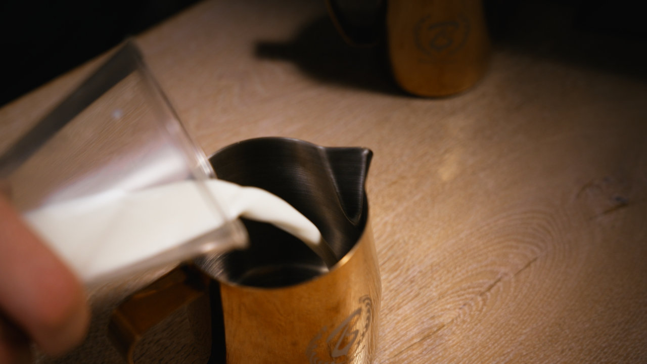 Milch wird in das Milchkännchen gegossen